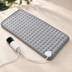 Model 406 grey dimpled heating pad with its wired controller on a pale stone surface