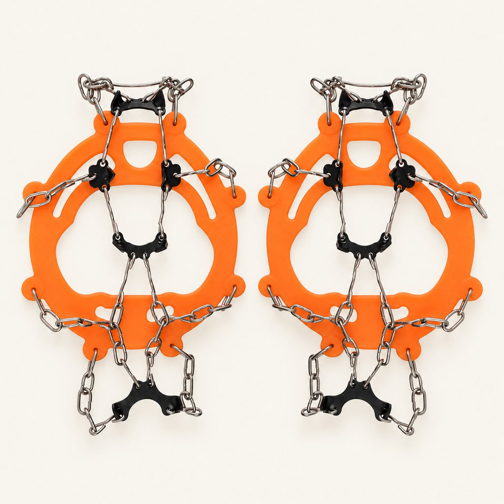 Orange adult chain ice grips with black underfoot plates and silver chains on warm ivory