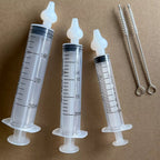 Three graduated manual syringes with detachable soft tips and two cleaning brushes