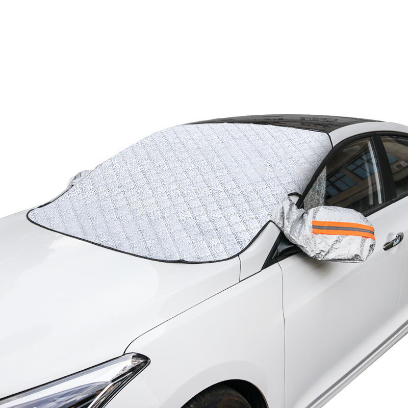 Silver quilted windscreen snow cover with reflective mirror covers on a parked car